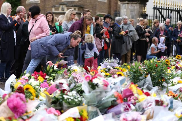 Members of the public lay Floral tributes to the late Queen Elizabeth II outside of The Cambridge Gates at Windsor Castle.