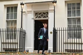 Britain's Chancellor of the Exchequer Jeremy Hunt walks out of Number 11 Downing Street 