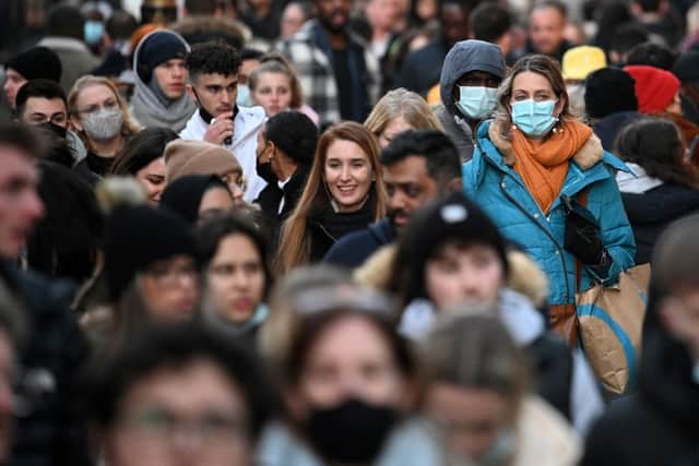 Shoppers, some wearing face-masks, walk along Oxford Street in central London (Getty Images)
