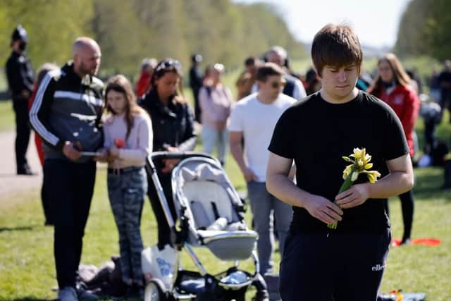Members of the public observe a minute's silence on the Long Walk in Windsor on April 17, 2021 to mark the start of the funeral service of Prince Philip, Duke of Edinburgh (Photo by TOLGA AKMEN/AFP via Getty Images)