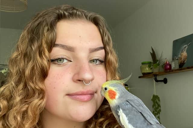 Grace Robinson, 19, with her pet cockatiel Kiki.