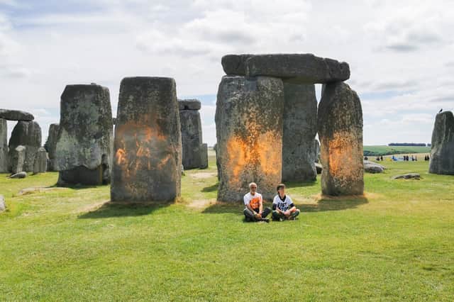 Activists sitting by Stonehenge after it was sprayed orange (Photo: Just Stop Oil/Supplied)
