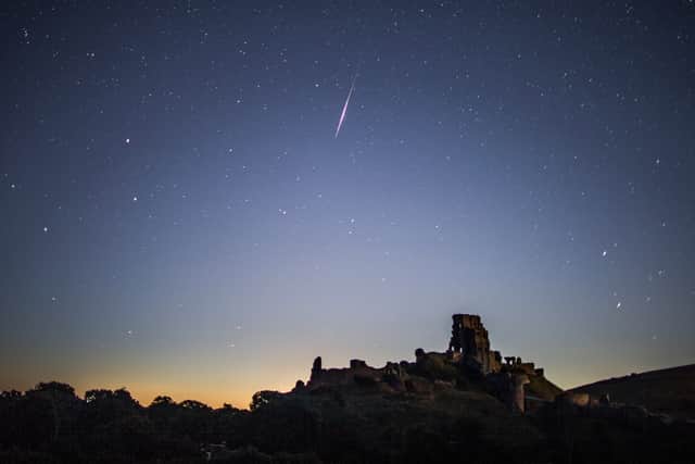 A meteor flashes across the night sky.