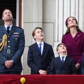 Prince William, Prince of Wales, Prince George of Wales, Prince Louis of Wales, Catherine, Princess of Wales and Princess Charlotte of Wales watch the Red Arrows flypast from Buckingham Palace.