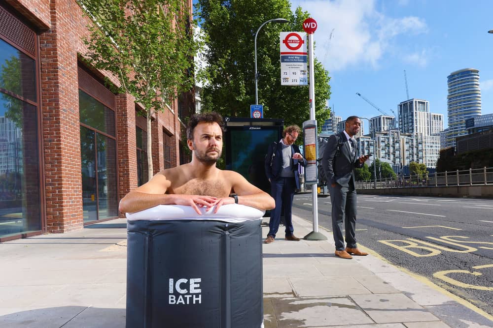A commuter takes an ice bath at a London bus stop