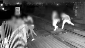 Men hold shut gates of level crossing in Barnsley, South Yorkshire.