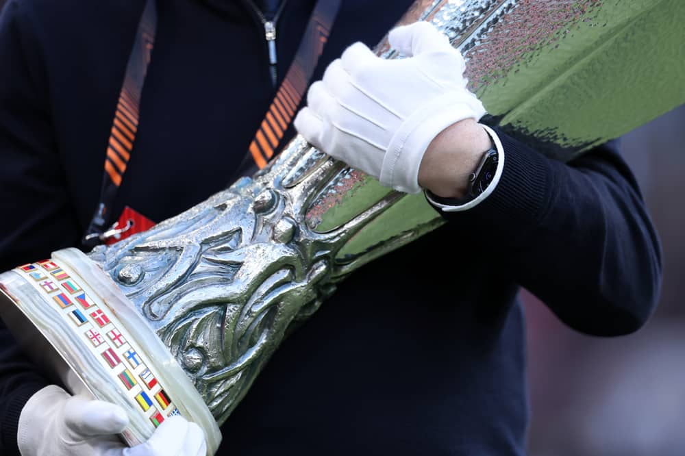 A UEFA official carrying the Europa Cup Trophy 