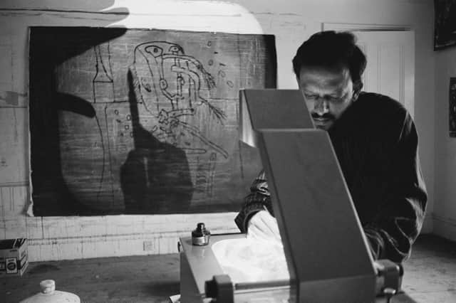 An artist uses an overhead projector in his studio