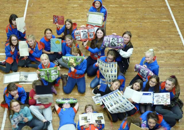 Members of the 2nd Scarborough (Westborough) Guides look through the group’s archive.