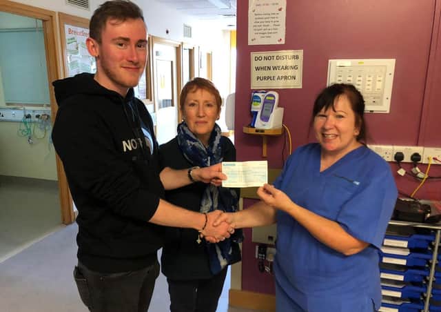 Jordan Butler and his mum Katrina Stead hand over the cheque for £300 to staff nurse Bridgette Smith.