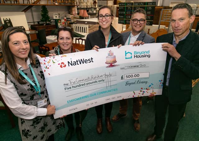 Andy Waites, Community Furniture Stores Chief Officer (right), is presented with a cheque for £500 by Beyond Housing staff members.