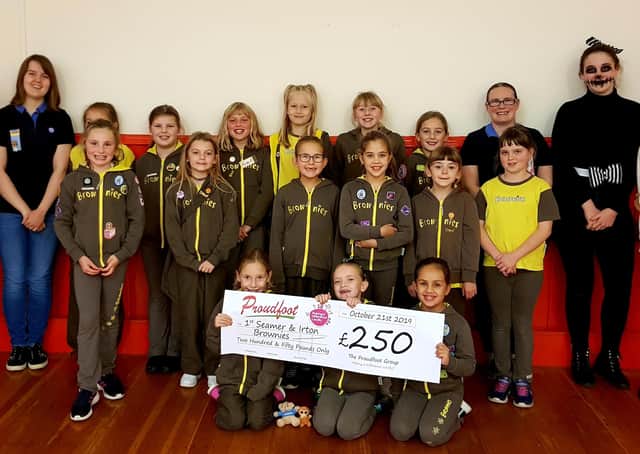 Members of the 1st Seamer and Irton Brownies are pictured with their cheque from Proudfoot supermarkets.