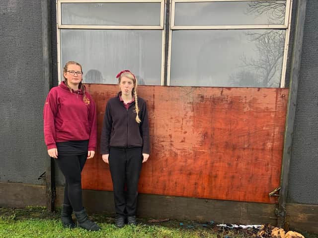 Demi-leigh Clark and Polly Jefferson standing by the damaged wall.