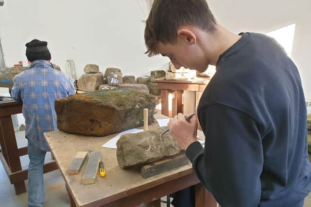 Matthew Mardall begins chiselling the outline of his father's initials