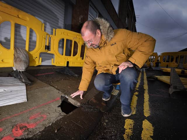Paul Bishop examines the sinkhole. Picture by Richard Ponter