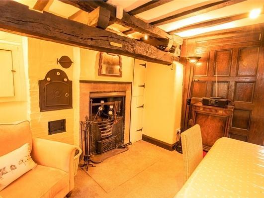 Beautiful features such as the cast iron fire and wooden panelled wall can be seen.