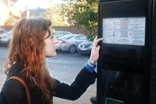 Woman at parking ticket machine.