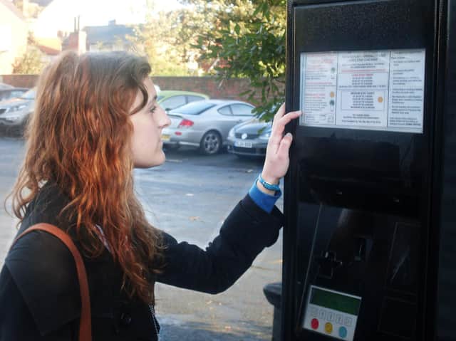 Woman at parking ticket machine.