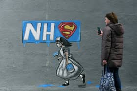 A woman looks at a mural of an NHS worker outside a pub in Pontefract, West Yorkshire. Pic: Jonathan Gawthorpe