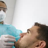 A doctor testing a patient suspected of having Covid-19 (photo: Salvatore Di Nolfi/Keystone via AP).