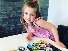Savannah Biggs poses with her creation, loads of nest cakes. As a six-year-old, those cakes probably won't be around for very long!