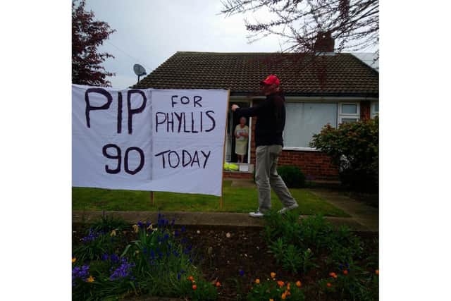 Barrie Watson puts up banner in his mum's garden