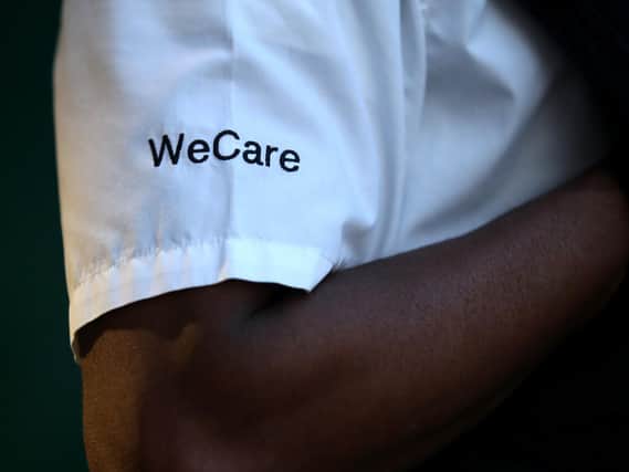 A detailed view of the shirt of a police officer reading 'WeCare'