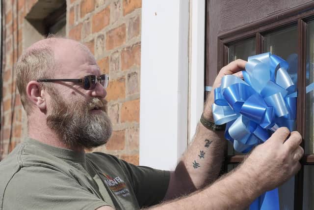 Durham Street resident Barry Croucher adding a blue bow to his door. Picture: JPI Media/ Richard Ponter