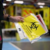 A paramedic holds a sign warning crew members not to enter a contaminated vehicle. Photo: PA