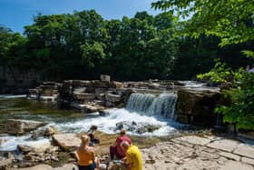 People enjoying the warm weather beside the River Swale at Richmond Falls. Picture Bruce Rollinson