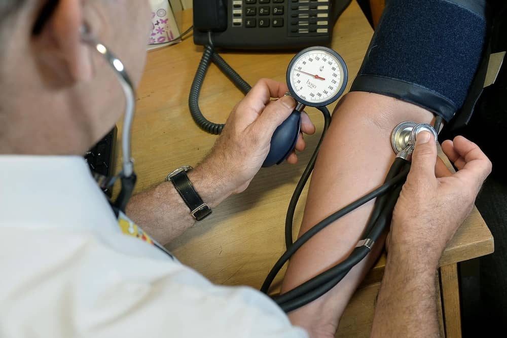 A GP checking a patient's blood pressure.