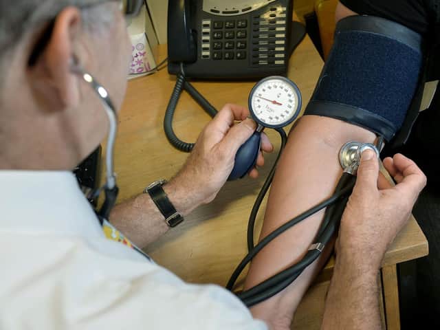 A GP checking a patient's blood pressure.