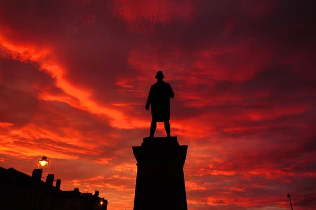 The sun sets over Whitby's Captain Cook statue.