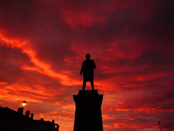 The sun sets over Whitby's Captain Cook statue.