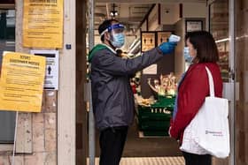 A woman has her temperature checked before entering a Chinese supermarket in Soho, London. fections. (Photo by Dan Kitwood/Getty Images)