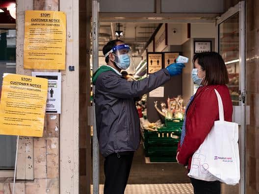A woman has her temperature checked before entering a Chinese supermarket in Soho, London. fections. (Photo by Dan Kitwood/Getty Images)