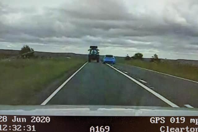 Footage of a car overtaking a tractor on a white line on the A169 near RAF Fylingdales.