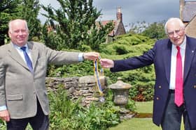 Rotary Club of Scarborough Cavaliers’ past president Tony Graham, left, presents the chains of office to new president Andrew Green.