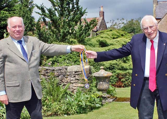 Rotary Club of Scarborough Cavaliers’ past president Tony Graham, left, presents the chains of office to new president Andrew Green.