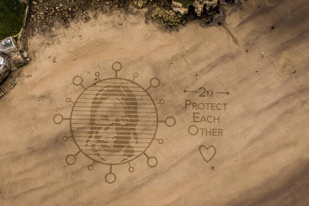 Beach art urging people to visit Whitby, and other resorts, responsibly.