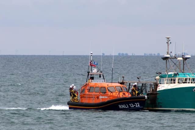 Bridlington lifeboat helps to bring the fishing boat into the harbour.