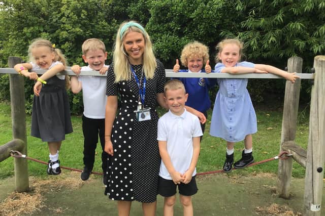 Award-winner Miss Jay Fenby with some of the youngsters of Stakesby School.