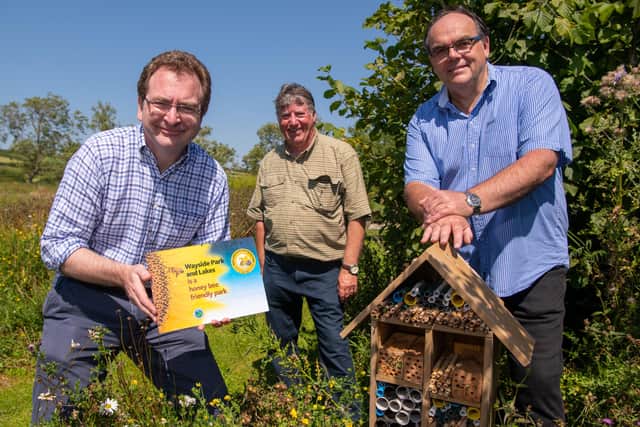 Rufus Bellamy, Trevor Jones and Mark Goodson with the award next to a bee hotel at the Wayside.