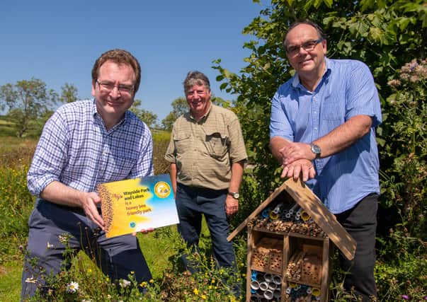 Rufus Bellamy, Trevor Jones and Mark Goodson with the award next to a bee hotel at the Wayside.