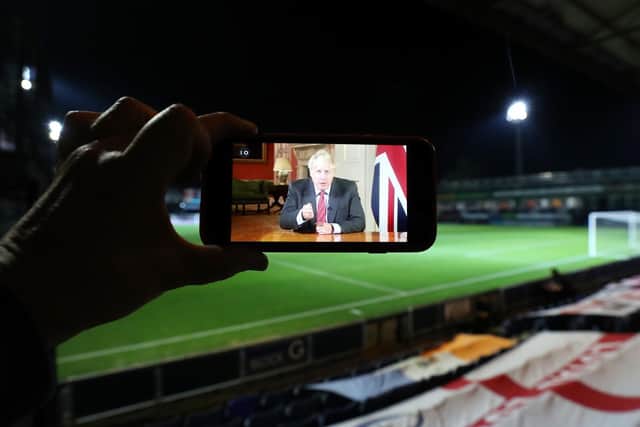 A video of Prime Minister Boris Johnson addressing the nation about Coronavirus on the screen of a mobile phone during the Carabao Cup third round match at Kenilworth Road, Luton. Photo: PA