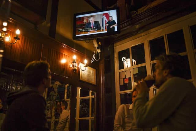 Drinkers in London watch Boris Johnson's announcement this week.