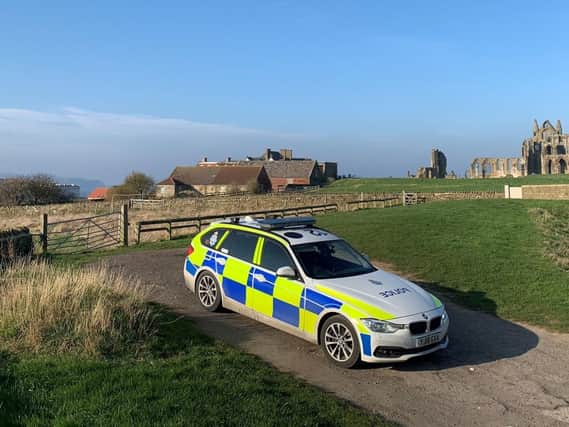 A North Yorkshire Police car on patrol at the ruins of Whitby Abbey. The Benedictine abbey - rebuilt in the 1220s - thrived for centuries as a centre of learning, before its destruction by Henry VIII in 1540 during the Dissolution of the Monasteries:
