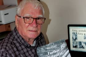 Author Mike Wilson is pictured with his new publication.