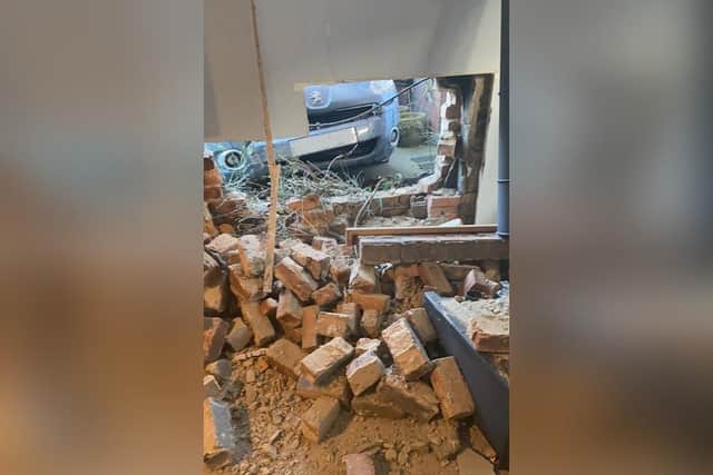 Damage to the house, with the car at the back