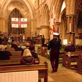Lifeboat station standard bearer Kev Roberts walking down the aisle at the start of the service.
